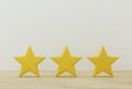 Yellow three star shape on table. The best excellent business services rating for satisfaction