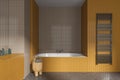 Yellow tile home bathroom interior with bathtub and towel rail