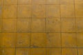 A yellow tiled old and worn down floor