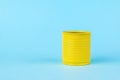 A yellow tin can on a bright blue background. Universal container Royalty Free Stock Photo