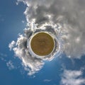 Yellow tiny planet in rapeseed field in blue sky with beautiful clouds. Transformation of spherical panorama 360 degrees. Royalty Free Stock Photo