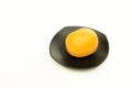 Yellow tomato on black squire plate Royalty Free Stock Photo