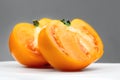 Yellow Tomato. Ripe natural tomatoe close-up. Organic tomato on grey background. Macro shot. Half of Tomato close-up