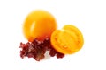 Yellow tomatoe with half slice and salad leaves on white Royalty Free Stock Photo