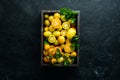 Yellow tomatoes in wooden box on black stone background. Top view. Royalty Free Stock Photo
