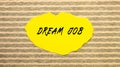 Yellow torn paper with the text DREAM JOB on a gray-pink background Royalty Free Stock Photo