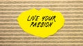 Yellow torn paper with the text LIVE YOUR PASSION on a gray-pink background Royalty Free Stock Photo