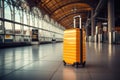 A yellow tourist suitcase is at the train station at the airport