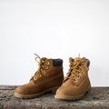 Yellow tourist winter boots on an old wooden bench on a white background