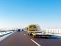 Yellow tow truck with empty platform moves on highway in winter Royalty Free Stock Photo