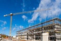 Yellow tower crane above a building under construction in scaffolding Royalty Free Stock Photo
