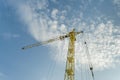 Yellow tower crane on a background of blue sky with clouds, industry abstract background Royalty Free Stock Photo
