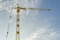Yellow tower crane on a background of blue sky with clouds, industry abstract background Royalty Free Stock Photo