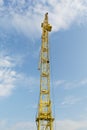 Yellow tower crane on a background of blue sky with clouds, industry abstract background Royalty Free Stock Photo