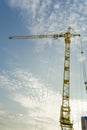 Yellow tower crane on a background of blue sky with clouds, industry abstract background Royalty Free Stock Photo