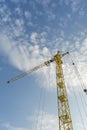 Yellow tower crane on a background of blue sky with clouds, industry abstract background Royalty Free Stock Photo