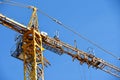Yellow tower crane while building a house against a blue sky Royalty Free Stock Photo