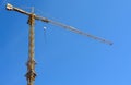 Yellow tower crane while building a house against a blue sky Royalty Free Stock Photo