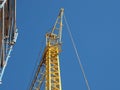 Yellow tower crane and scaffolding over blue sky Royalty Free Stock Photo