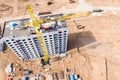 Yellow tower crane standing near new apartment building under construction. aerial view Royalty Free Stock Photo