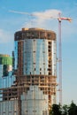 Yellow tower crane and unfinished building construction against blue sky Royalty Free Stock Photo