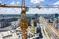 Yellow tower crane and unfinished building on foreground against blue sky. aerial photo Royalty Free Stock Photo