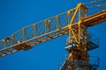 Yellow tower crane working on building against blue sky, selective focuse Royalty Free Stock Photo