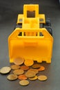 Yellow toy bulldozer, excavator carrying a lot of money - euro cent coins on dark background. Money digging, subsidies from Europe Royalty Free Stock Photo