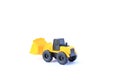 The yellow toy car Bulldozer isolated on white background. Children`s tractor toy. Wheel loader construction car model Royalty Free Stock Photo
