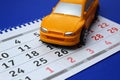 Yellow toy car on a calendar background