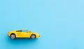 Yellow toy car isolated on blue background Royalty Free Stock Photo