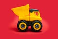 Yellow Toy Car Truck Over Red Background, studio shot Royalty Free Stock Photo
