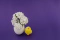 Yellow toy chicken sits next to the egg shell in which there are white flowers Royalty Free Stock Photo