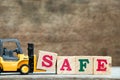 Yellow toy forklift hold letter block S to complete word safe
