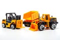 A yellow toy heavy machinery includes dump truck, bulldozer and forklift on white background