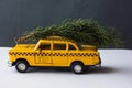 Yellow toy taxi on a tree trunk. Christmas. Royalty Free Stock Photo