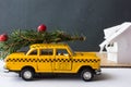 Yellow toy taxi on a tree trunk. Christmas. Royalty Free Stock Photo