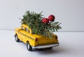 Yellow toy taxi on a tree trunk. Christmas. Royalty Free Stock Photo