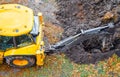 Yellow tractor excavator digs a pit with a bucket, accident. Breakthrough underground. Autumn winter top Royalty Free Stock Photo