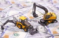 Yellow tractor and excavator. miniature models in dollars