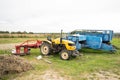 Yellow tractor with red bucket stands on the grass Royalty Free Stock Photo