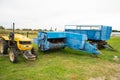 Yellow tractor with red bucket stands on the grass Royalty Free Stock Photo