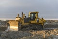 Yellow tractor in winter tundra. The road construction. Bulldozer