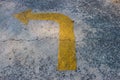 Yellow traffic arrow signage on an cement road