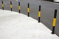 Yellow traffic bollards in front of glass wall at shopping mall