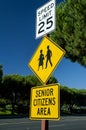 Yellow traffic sign that says Senior Citizens Area with graphic of senior citizens walking