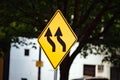 Yellow traffic sign with wavy black arrows