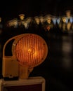 Yellow traffic signal illuminated from atop an overpass, with a backdrop of soft, blurred lights Royalty Free Stock Photo