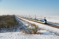 Yellow train in Dutch rural winter landscape