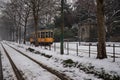 a yellow train is moving down the tracks in the snow